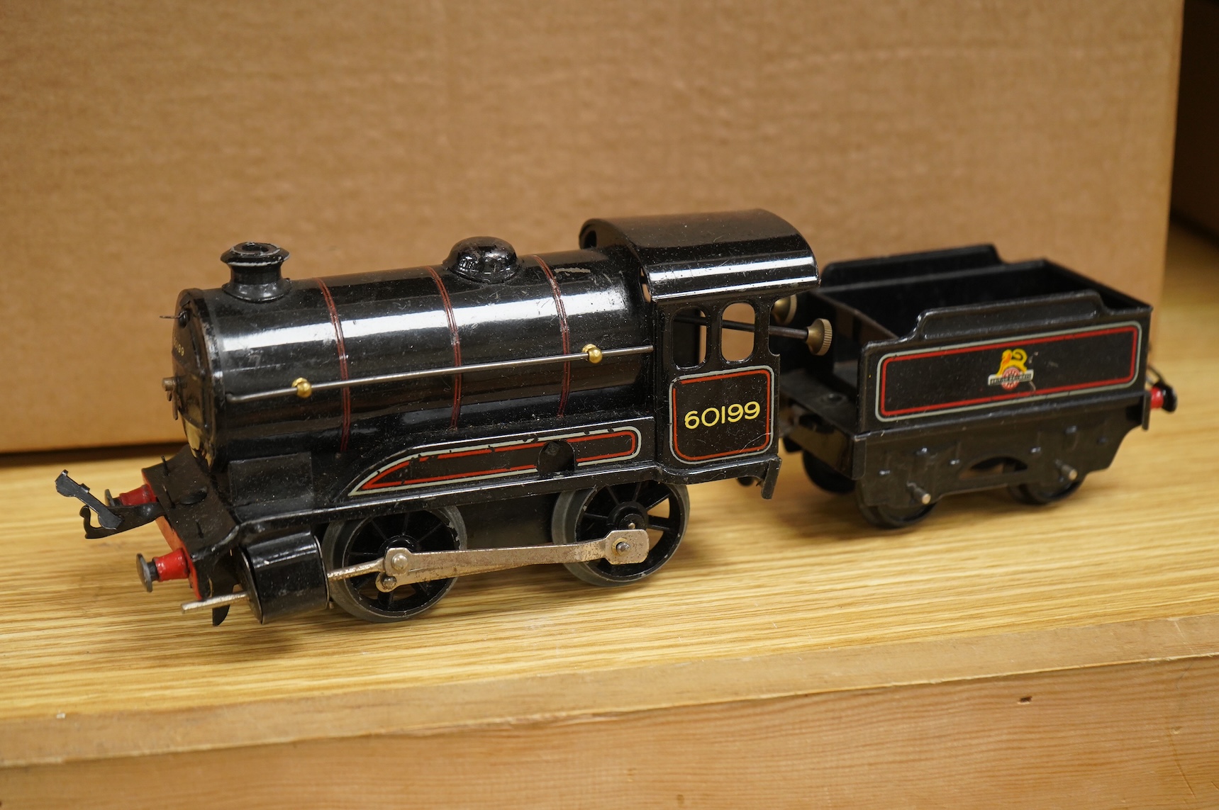 A collection of 0 gauge Hornby tinplate clockwork railway, including four BR locomotives, 17 freight wagons and four wheel coaches, together with a station building, signal cabin, and Goods depot (missing base), plus a f